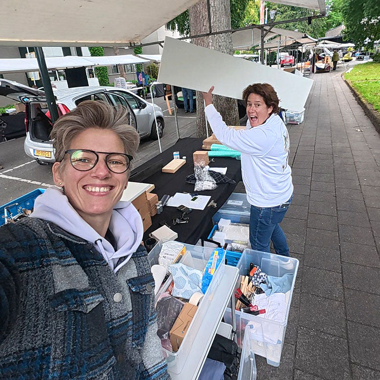 Quirine en Mirthe bouwen de marktkraam af